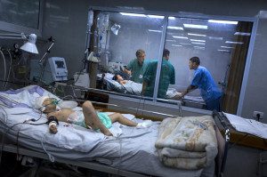 4.	Mads Gilbert, ahli anestesi dari Norwegia sedang berdiskusi dengan rekan-rekan Palestina-nya di  RS Shifa, mengenai dua bersaudara yang mengalami luka berat di bagian kepala. RS Shifa menerima korban-korban paling parah dalam serangan Israel. 