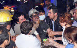 A rescued miner surrounded by relatives, medics and other miners cries after being rescued from a coal mine he was in trapped in Soma, a district in Turkey's western province of Manisa
