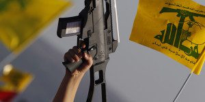 Child holds up plastic toy rifle and waves Hezbollah flag during rally to mark Quds Day in southern Lebanese village of Maroun el-Ras