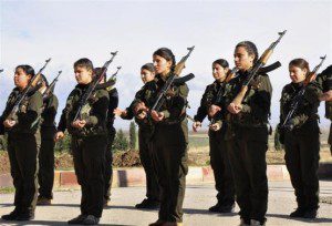 Kurdish female fighters of the Kurdish People's Protection Units hold their weapons at a military camp in Malikiya