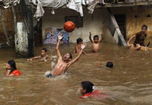 Anak-anak di Jakarta bermain-main saat banjir