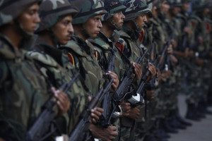 Army soldiers take their positions in front of protesters who are against Egyptian President Mohamed Mursi, near the Republican Guard headquarters in Cairo